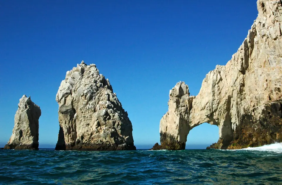 The rock arch and sea stacks at Land's End in Cabo San Lucas under a clear blue sky