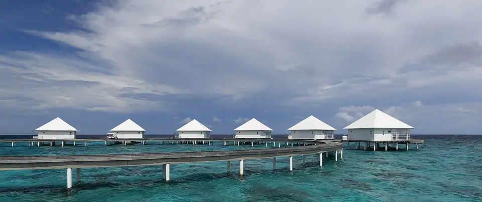 Row of overwater villas on stilts above a turquoise lagoon in Ari Atoll, Maldives