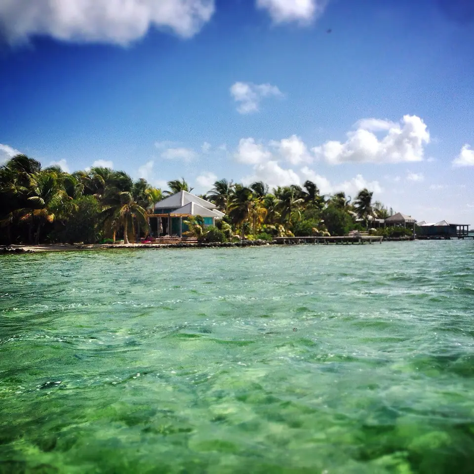 Cayo Espanto private island off Ambergris Caye, with palm trees, a white-sand edge and turquoise water