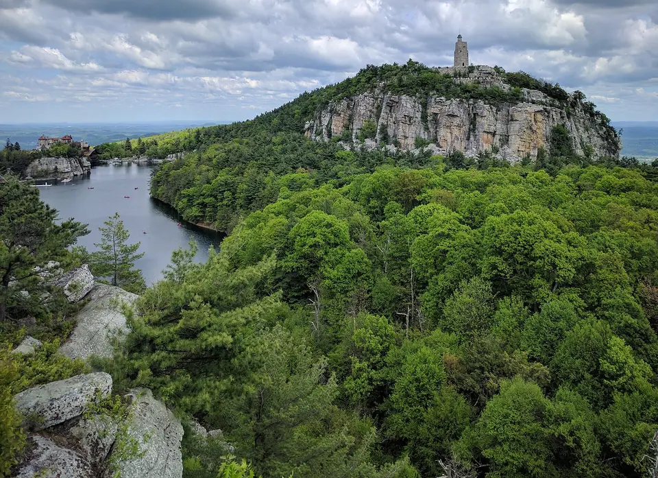 Lake Mohonk with the Mohonk Mountain House and Skytop Tower on the cliffs above, seen from a hiking trail